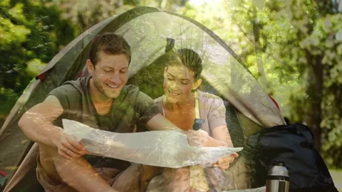 Camping couple reading map over forest animation Stock Footage 311036670