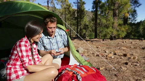 Camping couple in tent using smartphone - happy camper couple Stock Footage 42689641