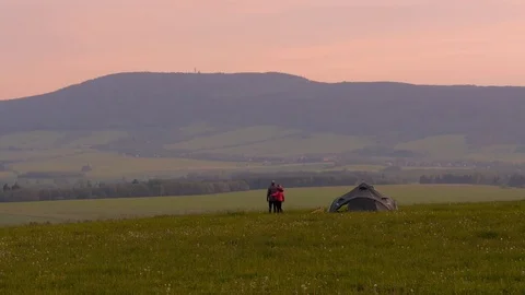 Camping couple, two people camping and looking at a surrounding landscape Stock Footage 77184515