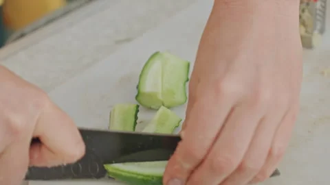 Camping cucumber slicing. Closeup of cucumber being sliced outdoors. Camping Stock Footage 334793664