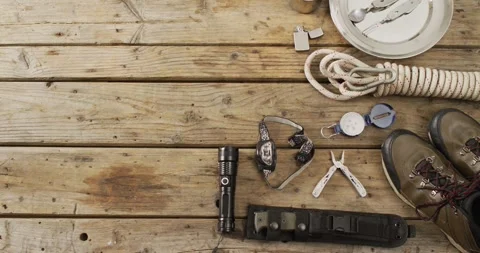 Camping equipment with rope, torch, boots and copy space on wooden background Stock Footage 345712432