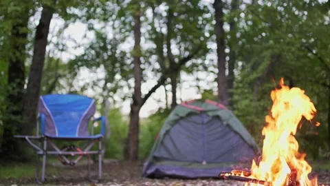 Camping in the forest. A small tent, a folding chair and a bonfire in nature. No Stock Footage 166946092