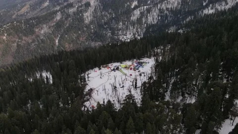 Camping ground campsite on the snow surrounded tall green pine trees. hikers  Video stock 157816248