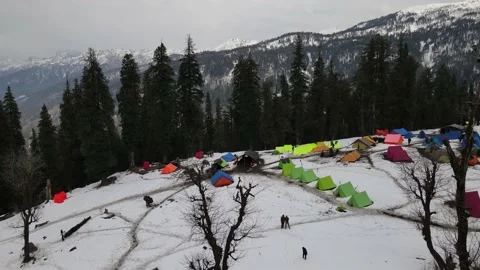 Camping ground campsite on the snow surrounded tall green pine trees. hikers  Stock Footage 157932306