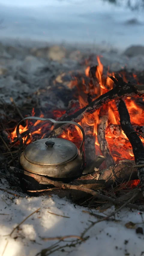 Camping kettle is boiling on the campfire Видео 329611479