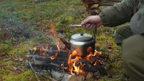 Camping kettle on a campfire in the forest Stockbeeldmateriaal 297179696