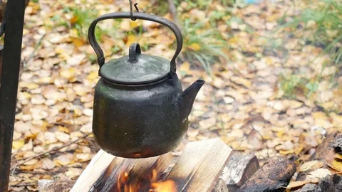 Camping kettle over burning campfire. Stock Photo