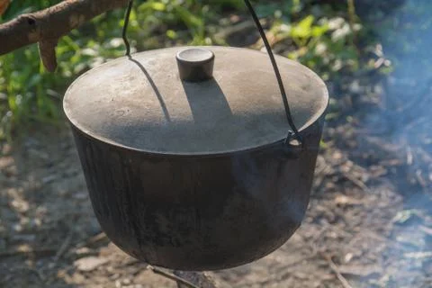 Camping kettle over the fire. Closeup. Stock Photos