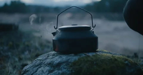 Camping. The kettle is standing on the stone in forest Stock Footage 128527347