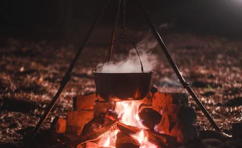 Camping Pot Over Fire at Night Stock Photos