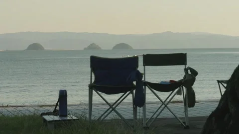 Camping Scene with Ocean View at Dusk, Two Chairs Overlooking Secluded Bay Video stock 268981282