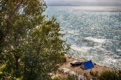 Camping at sea. Unity with the natural elements. Vacation at sea away from pe Stock Photos
