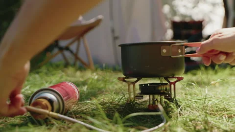 Camping setup with portable stove, preparing meal outdoors Stock Footage 308859859
