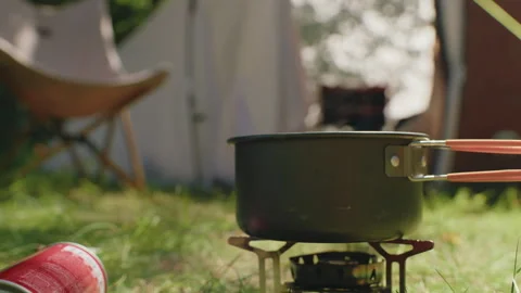 Camping setup with portable stove, preparing meal outdoors Stock-Footage 309384075