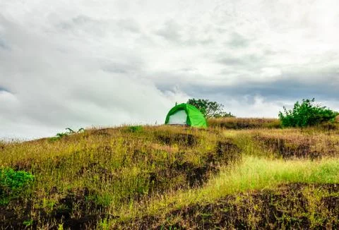 Camping solo at mountain top with dramatic sky Foto stock