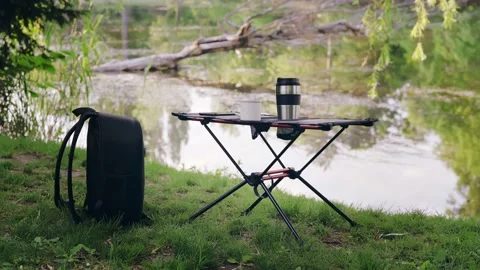 Camping table with cup of coffee outdoors Stock Footage 194538546