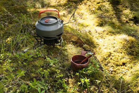 Camping teapot and mug with tea stand on green grass Stock Photos