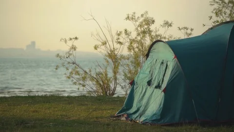 Camping tent under green tree on the beach with blue sea background in summer Stock Footage 115939824