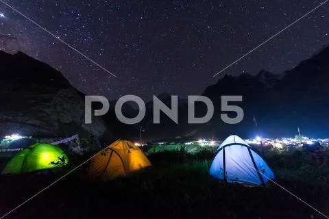 Camping tent under milkyway with twinkling stars in the background Stock Photos