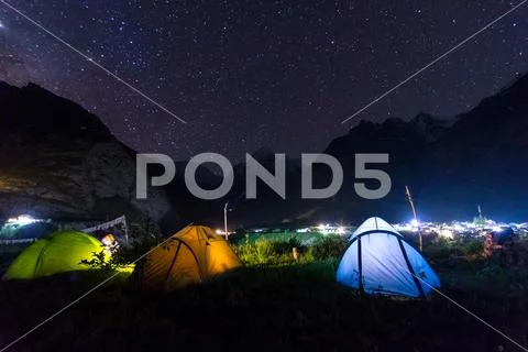 Camping tent under milkyway with twinkling stars in the background Stock Photos