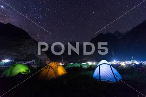 Camping under milkyway with twinkling stars in the background Stock Photos