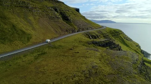 Camping van drives on empty coastal road Stock Footage 104800401