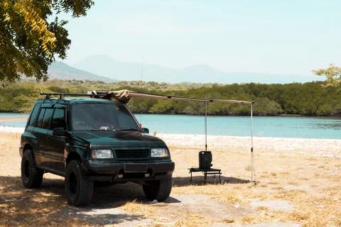 A camping van is parked on the shore of Baluran Sea with a stunning view of.. 스톡 사진