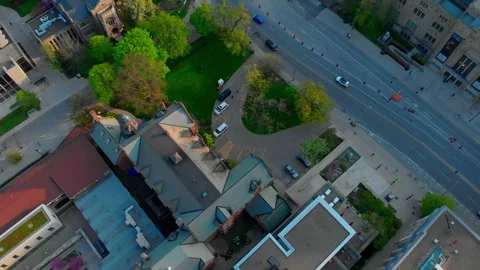 Campus aerial view rotating clockwise, revealing sunlit street with cars driving Stock Footage 307552549