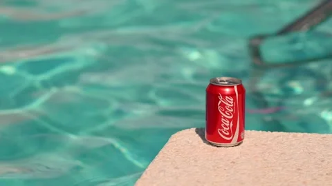 A can of Coca Cola stands on the edge of the pool in hotel Stock Footage 260716703