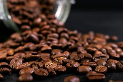 The can of coffee is turned upside down, with scattered beans. Macro copy spa Stockfoto's