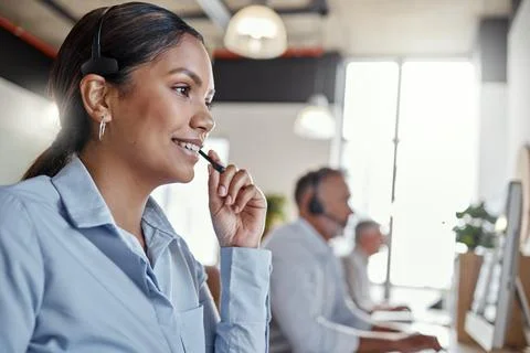 Can I repeat that back to you. a young woman using a headset in a modern office. Stock Photos