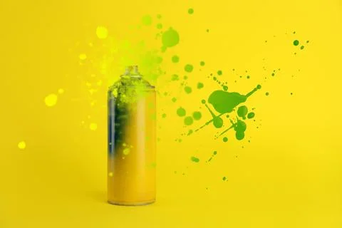 Can of spray paint and splatters on yellow background Stock Photos