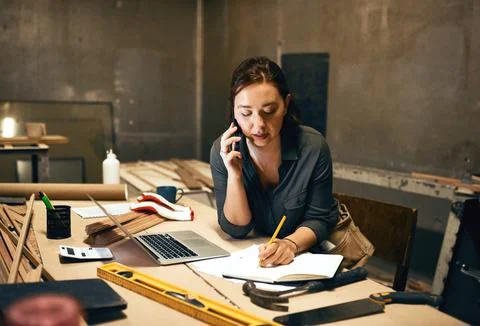 Can you repeat that please. an attractive young female carpenter working on her Stock Photos