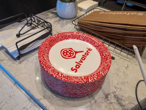 Canada, 20 July 2025 : Stack of branded pizza plates and napkins on restauran Stock Photos
