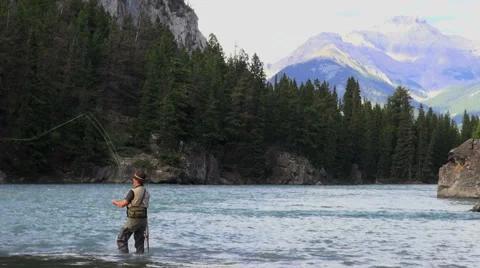 Canada Alberta Banff Bow River fisherman casting and mountain 3 Stock Footage 40599447