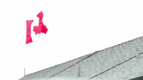 Canada Flag Blowing In Wind From Rooftop Stock Footage 154015328