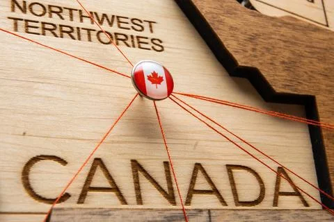 Canada flag on the pin with red thread showed the paths on the wooden map. Stock Photos