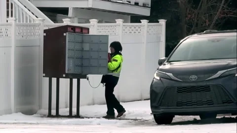 A Canada Post worker out on their delivery route in the winter. Stock Footage 330264711