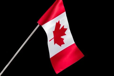 The Canadian flag on a black background developing and waving in the wind Stock Photos
