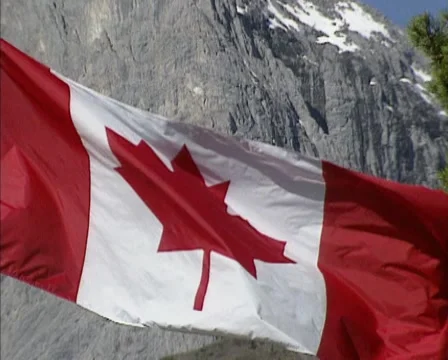 Canadian flag, the maple leaf, flying in front of Rocky Mountains. Stock Footage 40901604