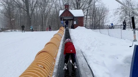 Canadian Young Child Learning to Ski in Winter while Snowing Vídeos de archivo 124442575
