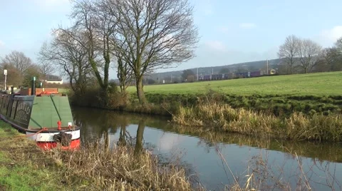 Canal barge narrowboat passing train Macclesfield canal rural setting Stock Footage 46446428