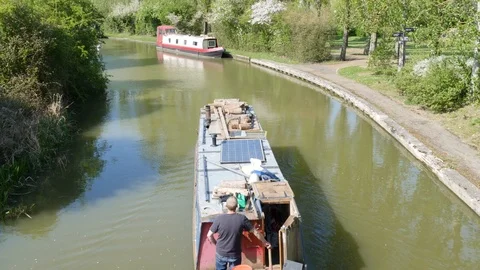 A canal boat tows another along the water 動画素材 106989475