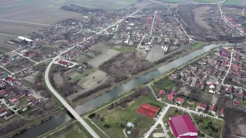 A canal DTD flows through small town Bac, Serbia, drone POV Stock Footage 258609458