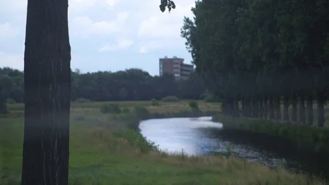 Canal With Trees, Clouds And A building Towards An Electrical Fence Stock Footage 126701091