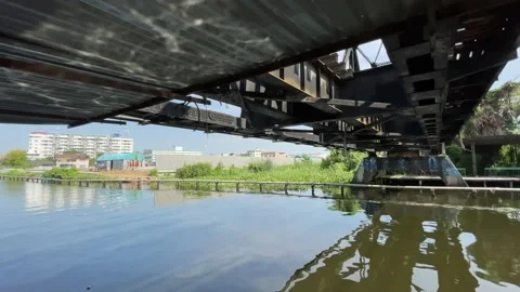 Canal under the train track at Taling Chan Floating market on a sunny day Stock Footage 172365809