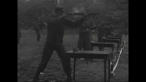 CANAL ZONE, PANAMA - 1962: Range volley - Smoke rises over a firing line Stockbeeldmateriaal 344005152