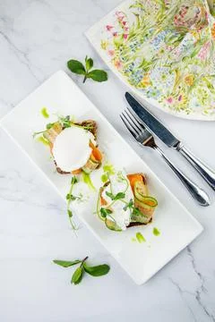 Canapes on black bread with cheese, red fish, herbs and cucumber top view Stock Photos