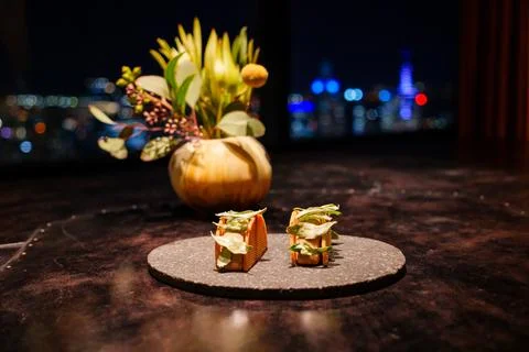 Canapes with crisp shells and herb garnish served in elegant night setting Stock Photos