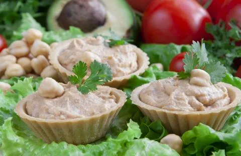 Canapes with hummus on a vegetable background Stock Photos
